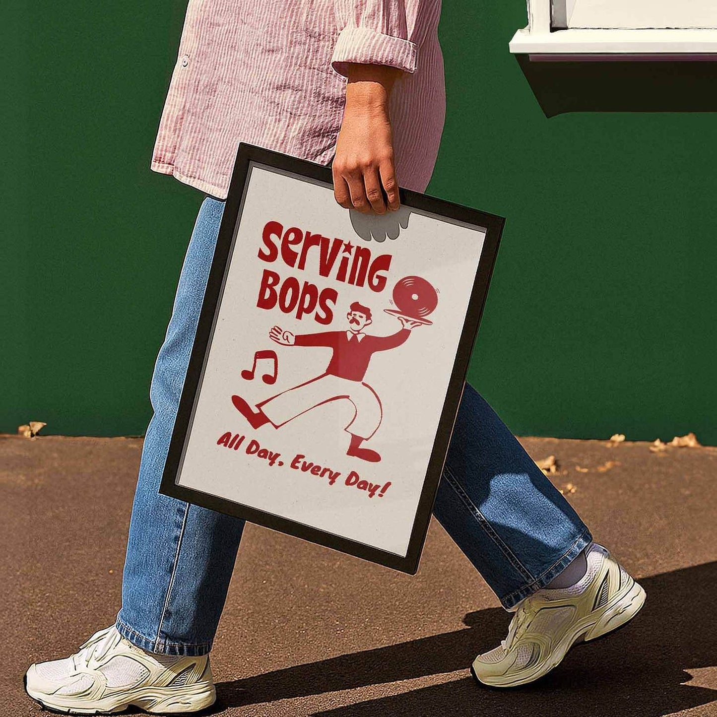 A person is walking while holding a framed sign that says "Serving Bops All Day, Every Day!"
