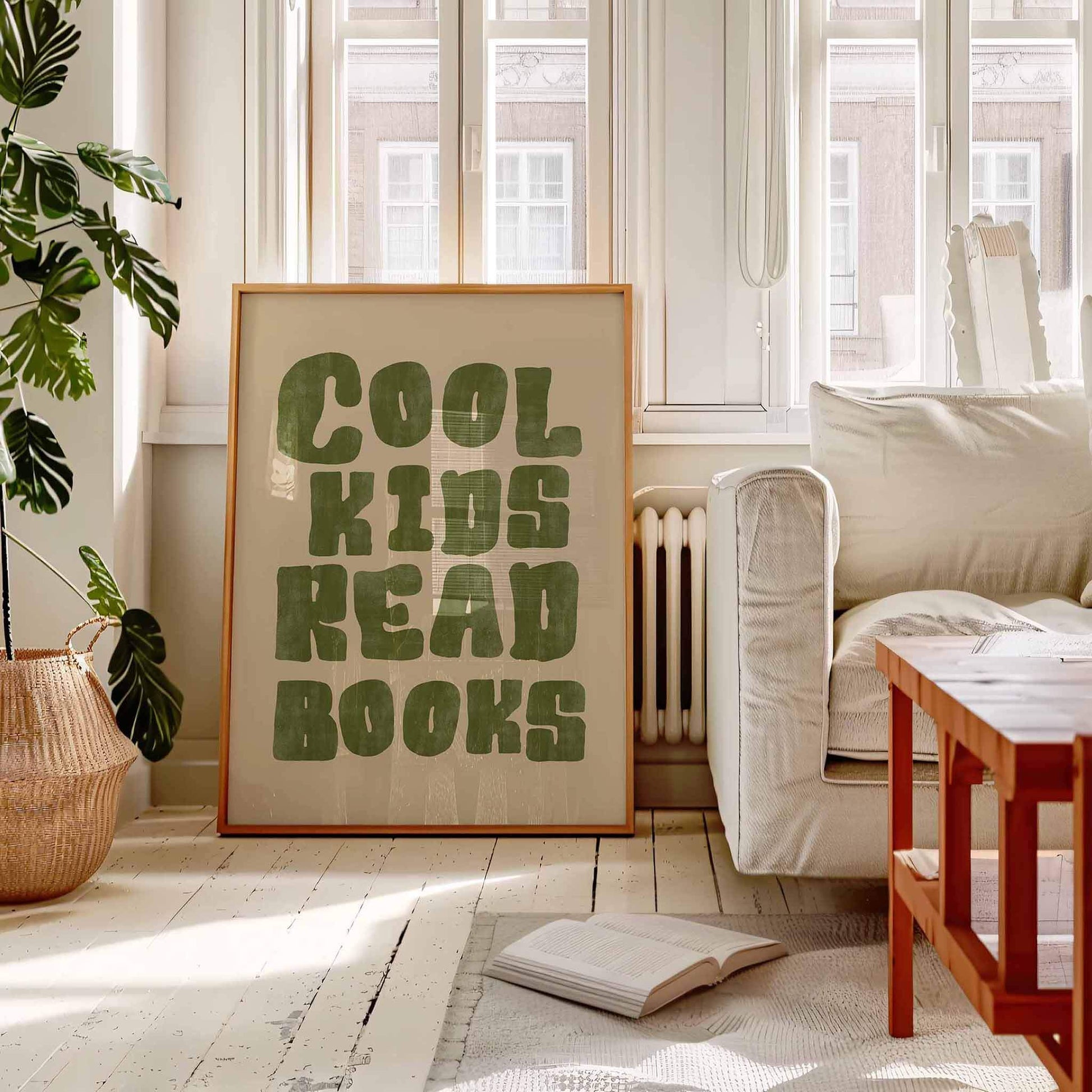 Room with a 'Cool Kids Read Books' poster on the wall, a couch, and an open book on the floor.