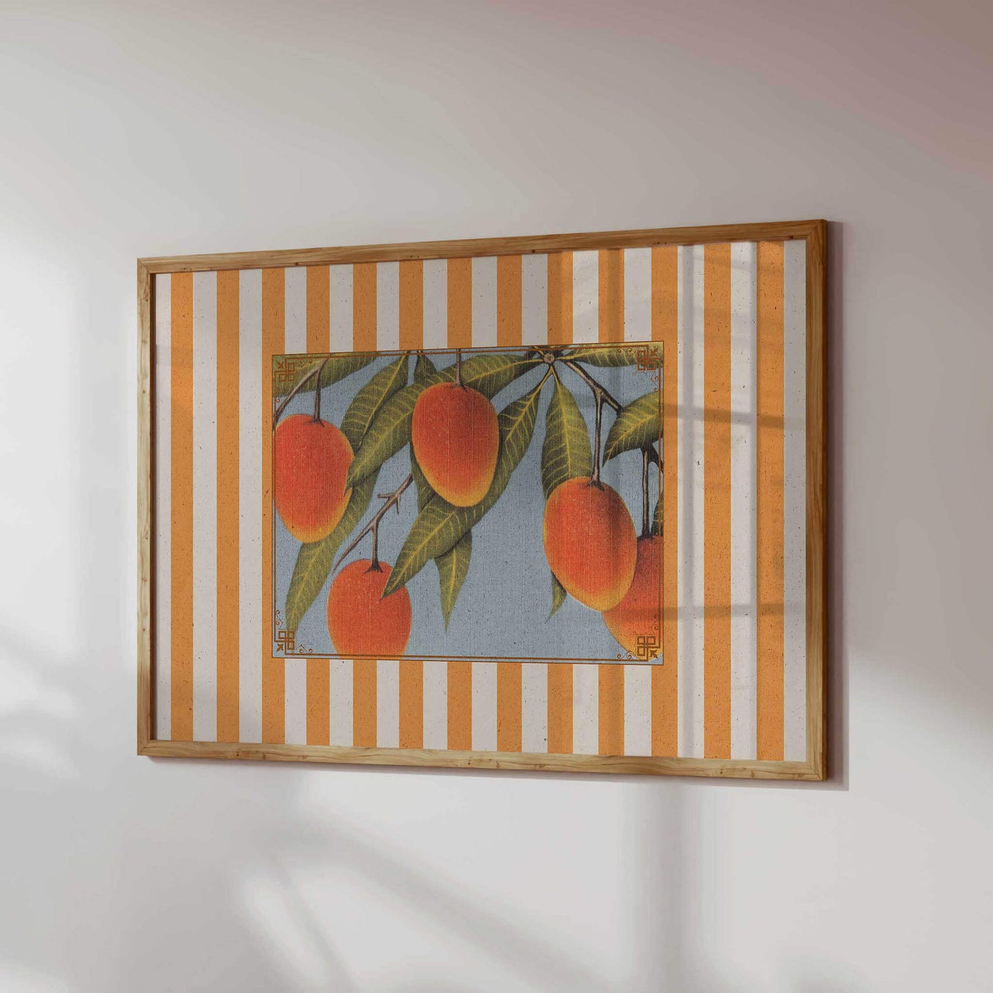 a framed artwork depicting a close-up of several ripe mangoes hanging from a tree branch.