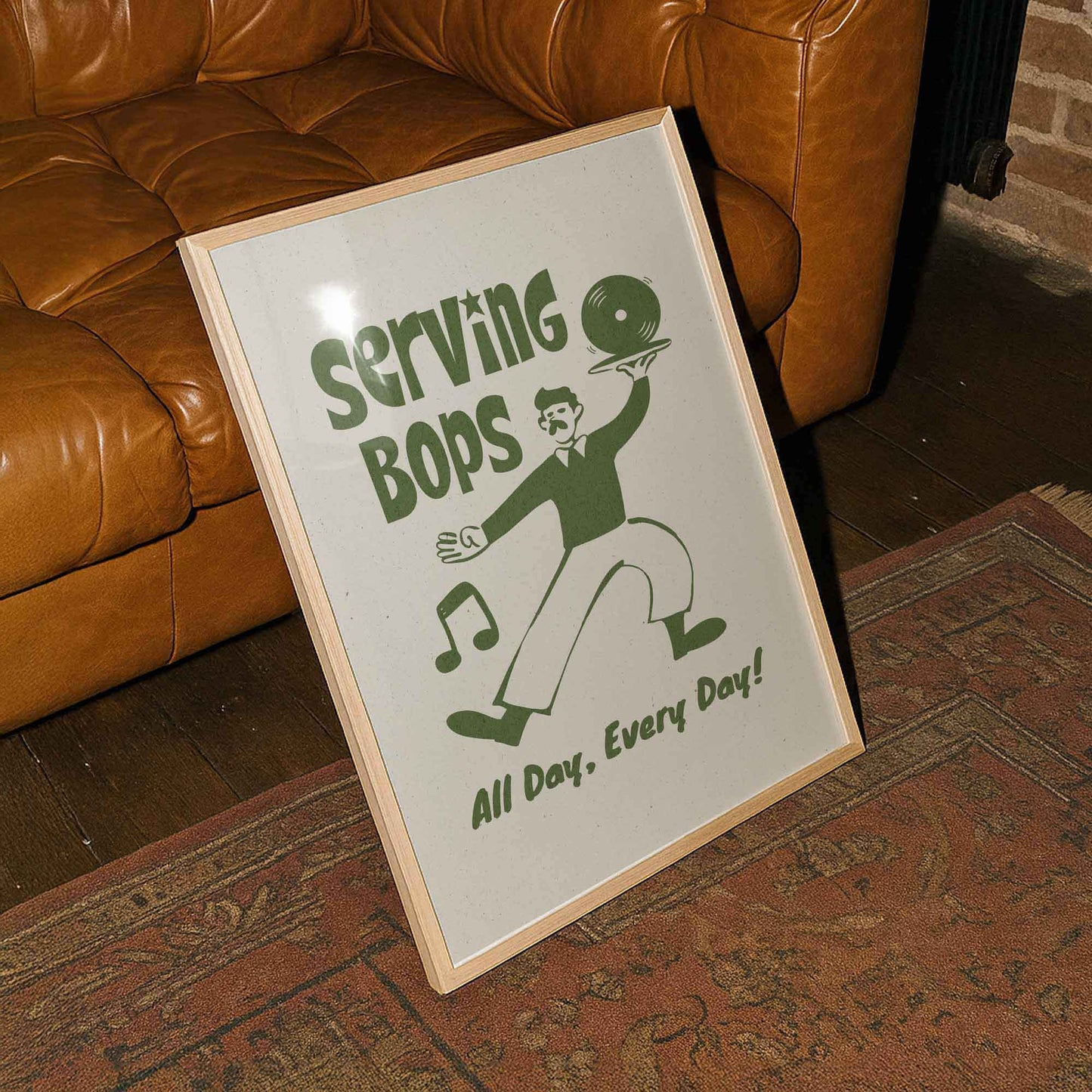 A framed poster with a cartoon illustration of a man serving food, accompanied by the text "Serving Bops All Day, Every Day!"