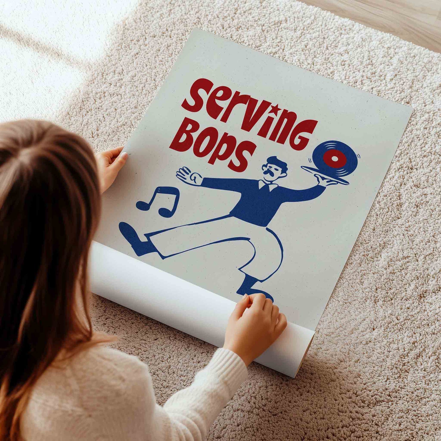 A person is standing on a carpet and holding a poster with a cartoon image of a man serving food.
